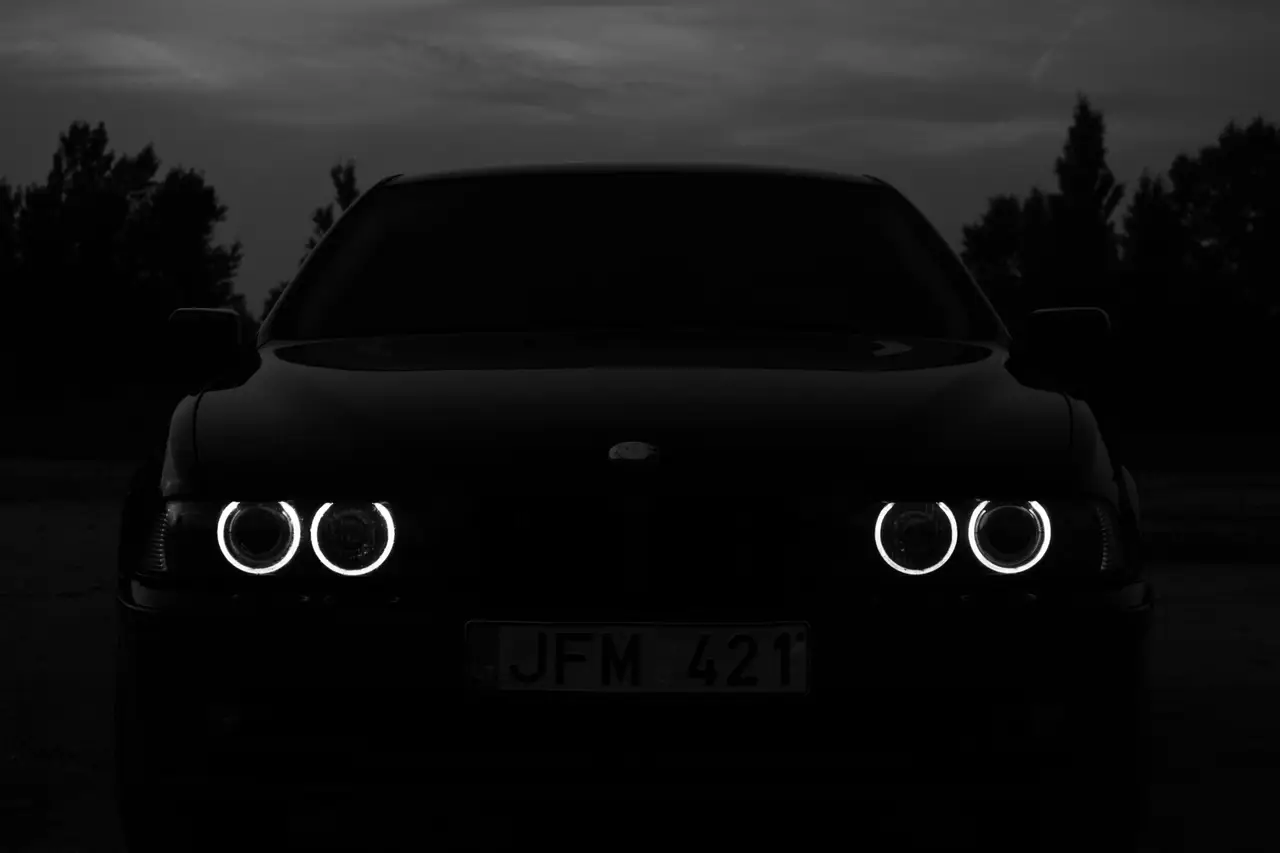 Dark performance car with illuminated headlights